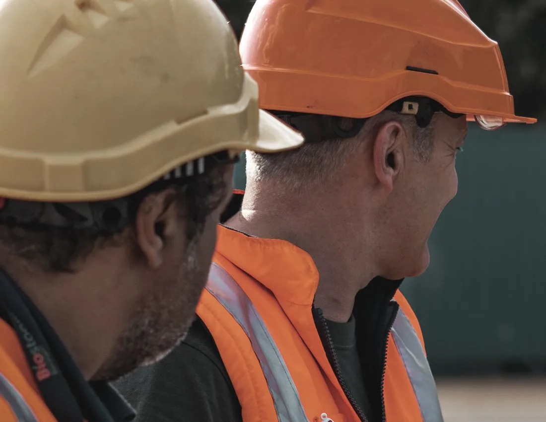 Trabajadores con casco y elementos de protección en faena