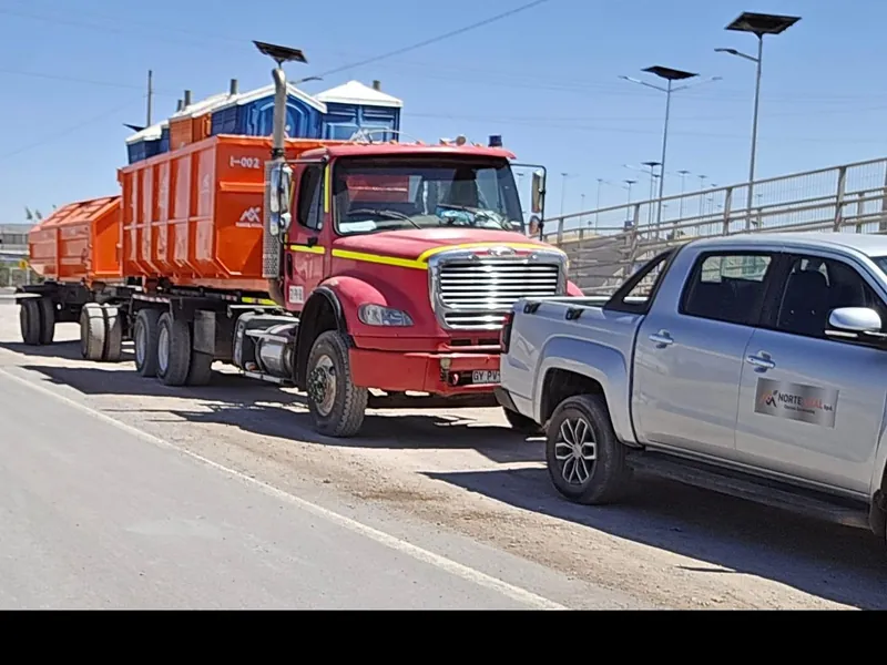 Camión con contenedor roll-off y camioneta de Norte Vital SpA en ruta hacia la faena